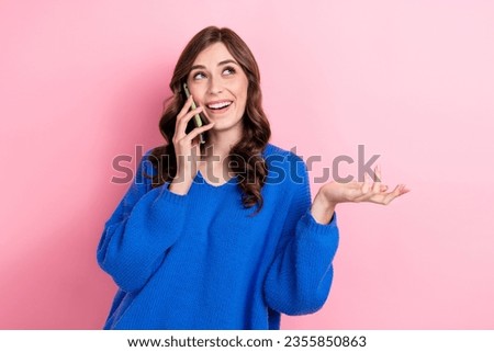 Photo of positive lovely girl wear stylish blue sweater speak friends look up empty space offer ad isolated on pink color background