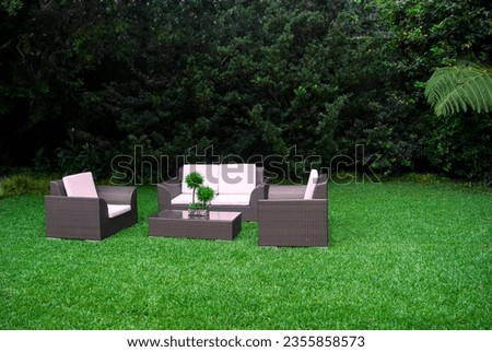 Plastic room installed in outdoor garden, ornamental detail in space covered by grass and old trees.
