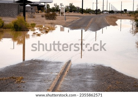 flooded muddy street area in Maricopa Arizona after summer monsoon storm Royalty-Free Stock Photo #2355862571