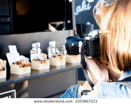 Woman taking pictures during the Hamburger food truck festival, Alicante, Valencian Community, Spain.