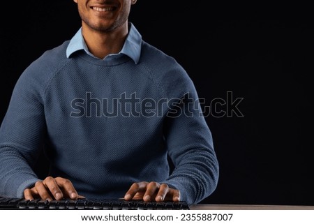 Biracial businessman using computer with copy space on black background. Technology, digital networks, global connections and communication metaverse.