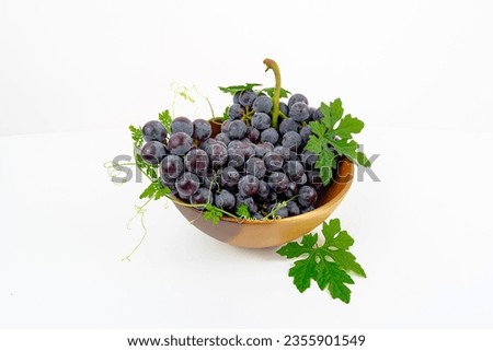 fresh fruit Purple grape Kyoho Grape with leaves in a wooden cup isolated on white background