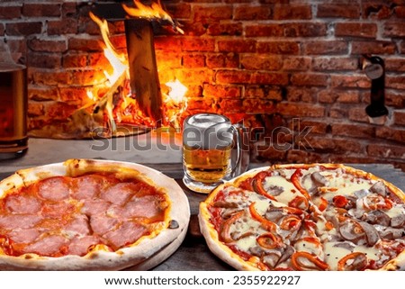 Pizza with ham, cheese and tomatoes and a glass of beer