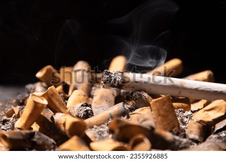Smoldering cigarette and smoky on the ashtray Royalty-Free Stock Photo #2355926885
