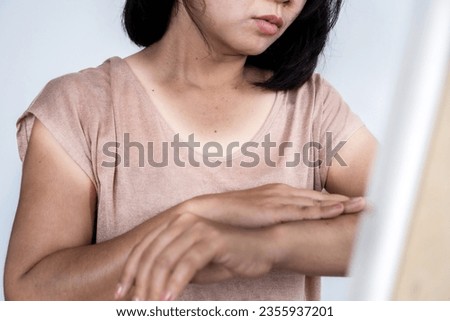 Asain woman with skin pigmentation on neck and arms, caused by sunburn, sun exposure make dark and damage skin   Royalty-Free Stock Photo #2355937201