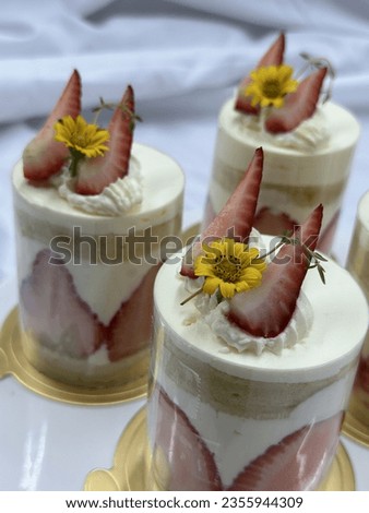 Strawberry shortcake on a wooden plate. strawberry blueberry  topping Very shallow depth of field. Fresh Strawberry  topping with cream and yellow flower. Bakery picture free space for text