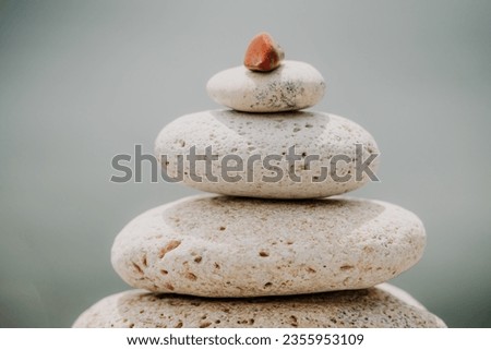 Calm pebble beach with pyramid stones and warm sunset on the sea background. Perfect travel destination for happy holidays, meditation, and relaxation at spa. concept of calmness and tranquility.