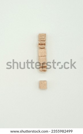 punctuation mark exclamation mark stacked from wooden cubes on white background