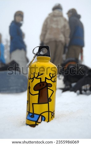 A bottle with a picture of a deer standing on the snow. Selective focus area