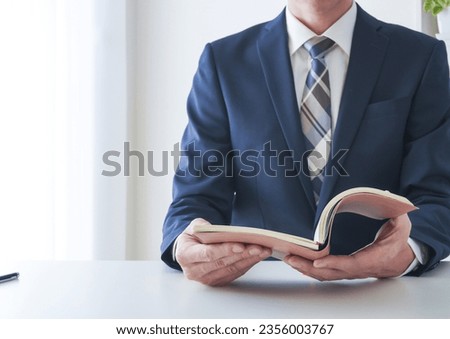 Businessman looking at a booklet Royalty-Free Stock Photo #2356003767
