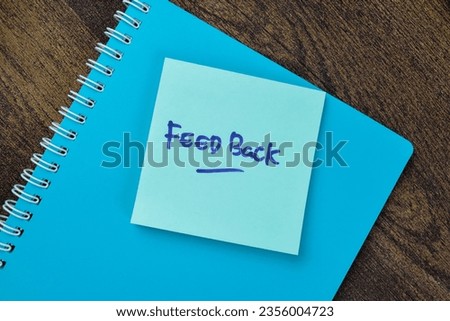 Concept of Feed Back write on sticky notes isolated on Wooden Table.