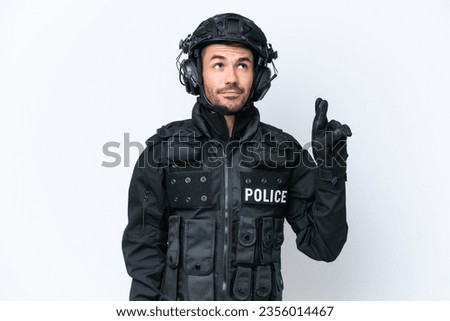 Young caucasian SWAT man isolated on white background with fingers crossing and wishing the best