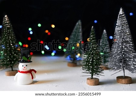 Happy new year 2024.cute snowman and Christmas tree on colorful bokeh lights background. New year or Christmas decorations concept.