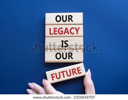 Our Legacy is our Future symbol. Concept words Our Legacy is our Future on wooden blocks. Businessman hand. Beautiful deep blue background. Business concept. Copy space