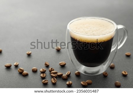 double wall glass cup of espresso and coffee beans on grey table Royalty-Free Stock Photo #2356031487