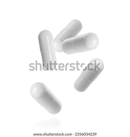 Many pills falling on white background. Four capsules in air Royalty-Free Stock Photo #2356034239