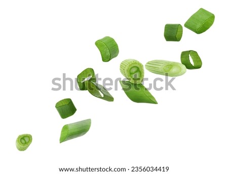 Cut green onion falling on white background Royalty-Free Stock Photo #2356034419