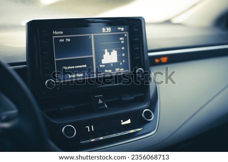 Modern LCD display with milage range fuel economy charts, high temperature setting knobs, inside new car, defrost mode fan at full blast for defogger windshield windows. AC, climate control panel Royalty-Free Stock Photo #2356068713