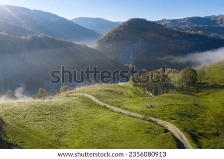 Morning haze in the mountains. Aerial drone view of autumn countryside hills in Transylvania, Romania
