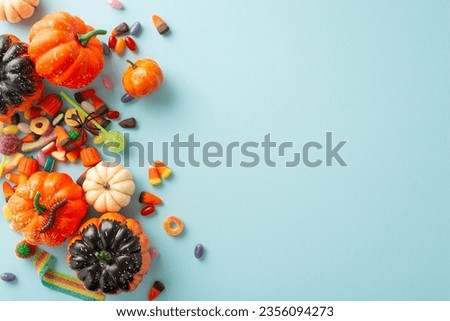 Delightful Halloween candy collection by kids. Top view picture showcasing a pumpkins with treats and Halloween decorations on a light blue isolated background, versatile for text or ad use