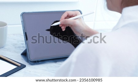 Back view of woman using digital tablet for working  to search on web page, technology, website, Business and technology concept. Working with tech device.