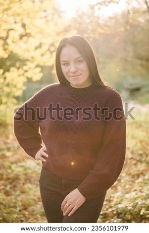 Autumn girl. Female walk in yellow leaves in forest with sunlight. Portrait woman, mother in park. Family spending time at sunset on vacation. Autumn holiday in nature. Closeup. Spring mood photo