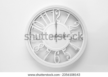 Modern white clock with a circle on a white wall background, three o'clock on the clock Royalty-Free Stock Photo #2356108143