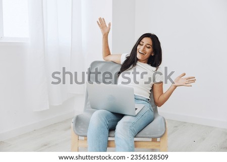 Woman relaxing at home sitting in a chair with a laptop, lifestyle home mood. Mockup, free copy space