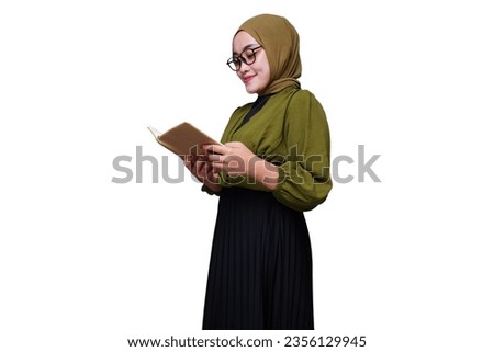 Smiling asian hijab woman reading a book
