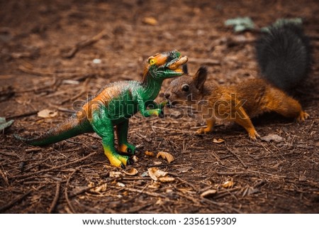 A red squirrel takes food from a toy dinosaur in the forest.