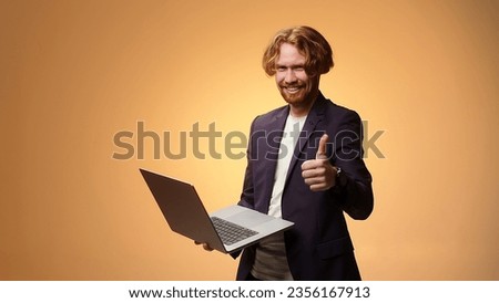Charismatic businessman with laptop is typing and showing thumb up. Online business concept