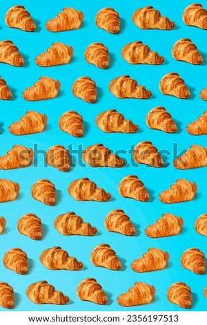 Pattern with croissants on a minimal blue background. Top view, flat lay, modern minimal image concept.