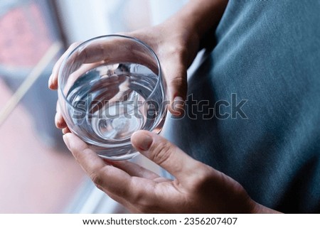 Pregnant woman holding a glass of water, body hydration, drinking plenty of fluids, healthy pregnancy Royalty-Free Stock Photo #2356207407