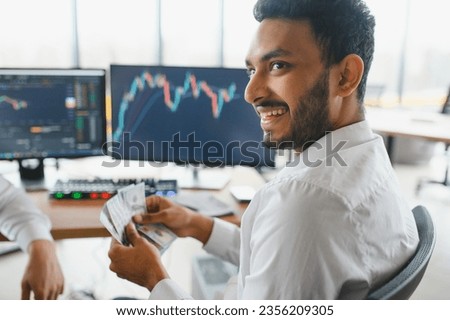 Portrait of a positive successful Indian or Arabian trader, stock market broker, Crypto charts on laptop screen. Royalty-Free Stock Photo #2356209305