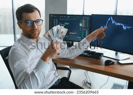 Holding Dollar bills in the stock market. Investors counting money after making it big on the stock market. becoming rich and wealthy. online stock market information Royalty-Free Stock Photo #2356209665