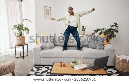 Dance, black woman and listening to music on the sofa for freedom, the radio or an audio. House, streaming or African girl with headphones for a podcast, playlist or enjoying a song on the couch