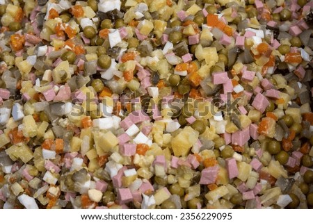 Fresh homemade vegetarian salad in Russian or Olivier made of potatoes, carrots, peas, hard-boiled eggs and mayonnaise dressing. Background picture.
