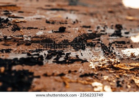 Abstract contemporary paint black oil strokes and glow golden shiny bronze texture. Artistic background. Smear brushstroke. Macro details