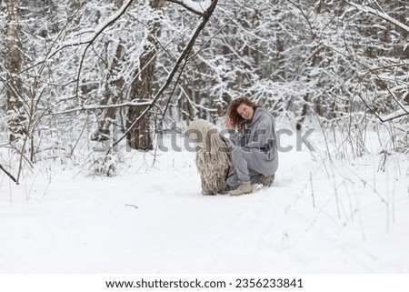 A girl with a dog walks in the forest in winter. High quality photo