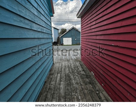 A wooden alleyway between two small buildings.