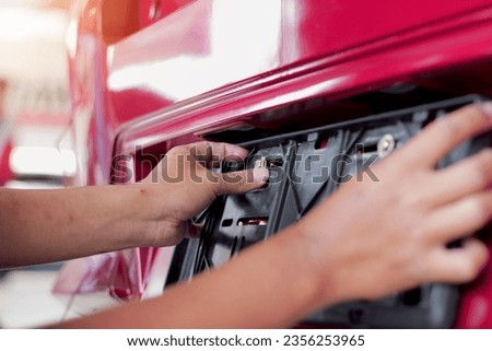Technician changing car plate number in service center. Royalty-Free Stock Photo #2356253965