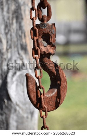 Rusty hook block and tackle hanging on a chain Royalty-Free Stock Photo #2356268523