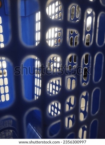 a blue basket with holes for clothes