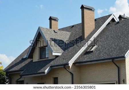 House asphalt shingles rooftop with dormer window, attic skylights, rain gutter, soffits, roof vents. Royalty-Free Stock Photo #2356305801