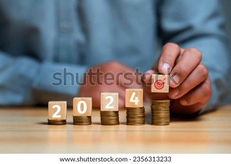 Businessman showing wodden cubic with stacking coin with  word 2024 for business planing in new year concept. marketing financial and research analysis, business planning and strategy concept.