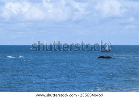 Blue sea with reef, cliffs and boat at sea