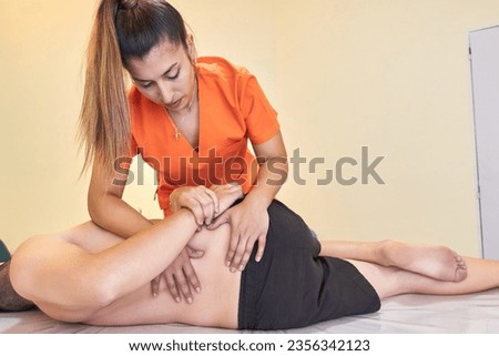 Masseur readjusting a patient's lumbar spine lying on a clinic Royalty-Free Stock Photo #2356342123
