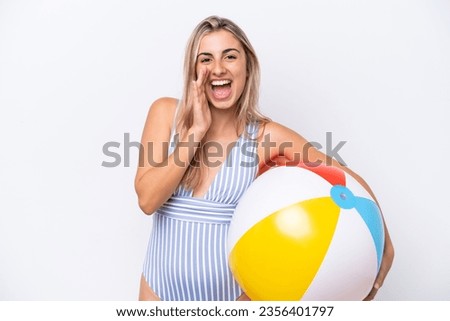 Young caucasian woman holding beach ball isolated on white background shouting with mouth wide open