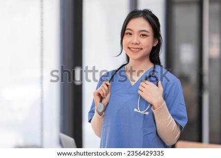 Portrait of Young Asian smiling female nurse in hospital corridor. Smiling asian woman doctor wear uniform in hospital corridor