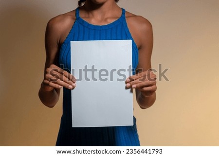 Young woman in a blue tight-fitting dress holding a blank sign